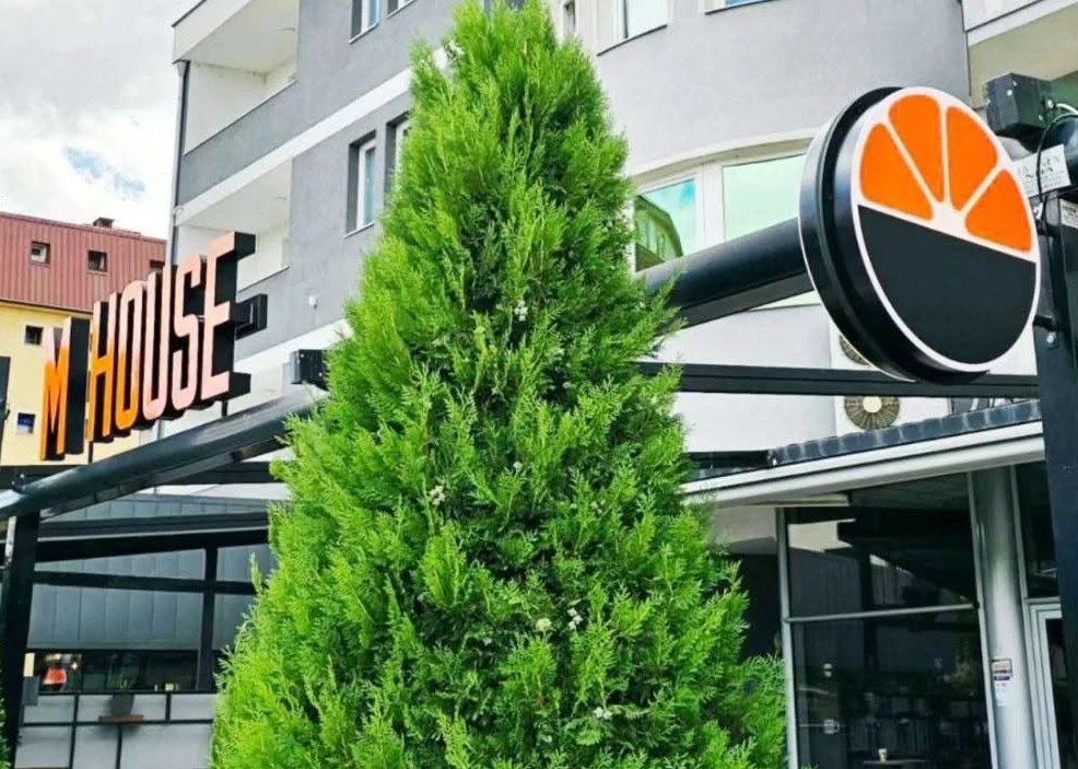 M House: 3D lettering and round sign in front of the building
