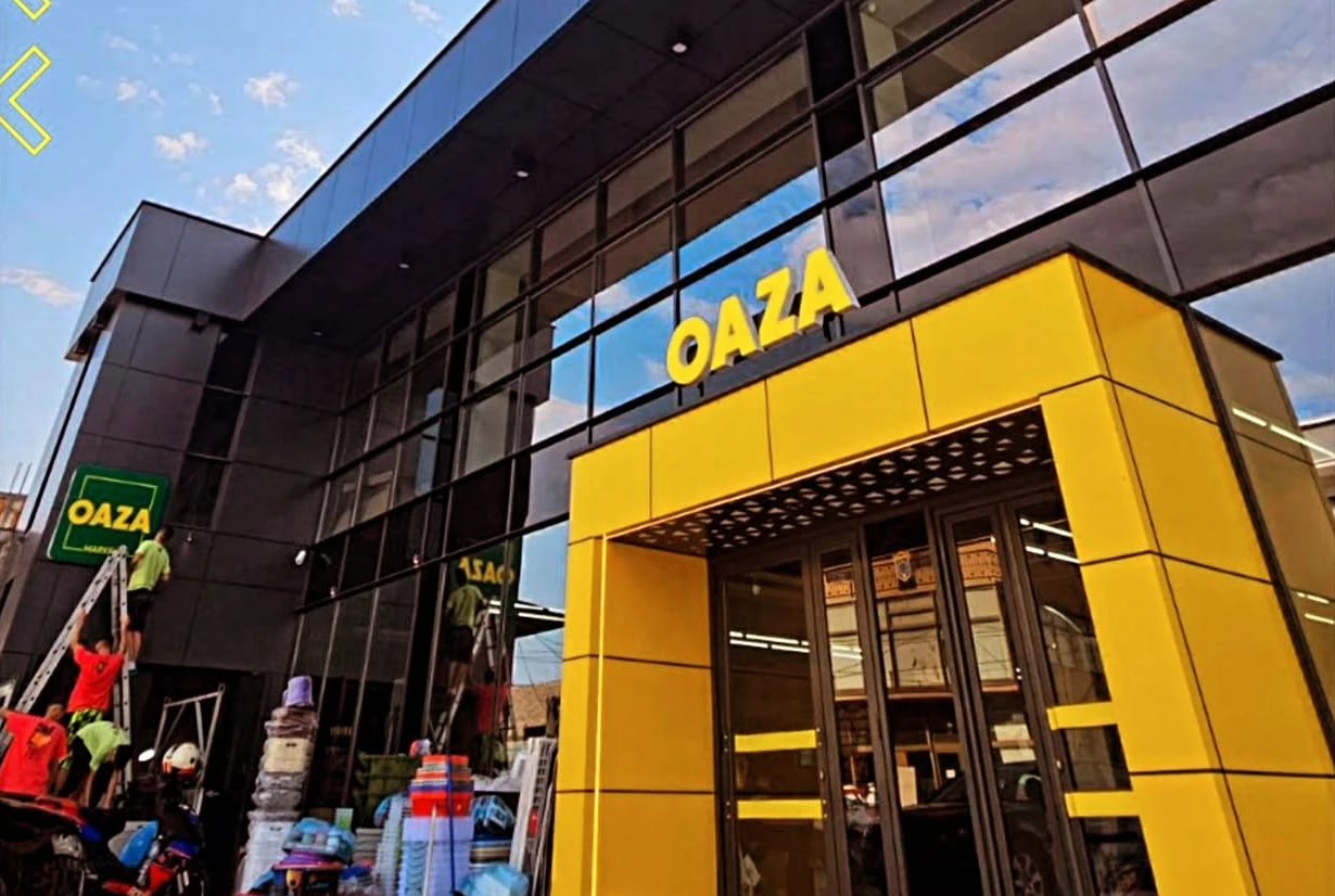 Façade of the OAZA market with 3D lettering and yellow entrance